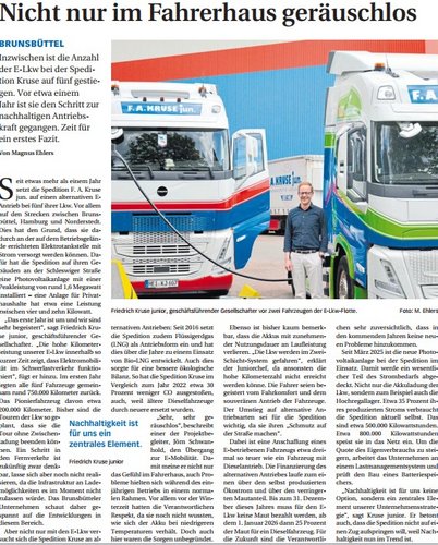 Zeitungsartikel mit Foto von zwei LKWs und einem Mann dazwischen vor einem Firmengebäude.